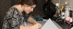 student at a desk drawing
