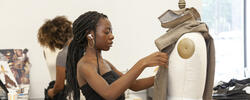 student pinning fabric to a mannequin