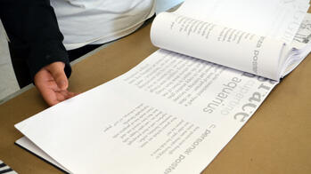 student looking at a printed booklet