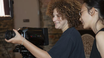two students working on a camera