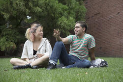 two students sitting in the grass
