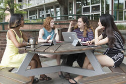 four students at a table outside