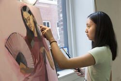 student painting a portrait